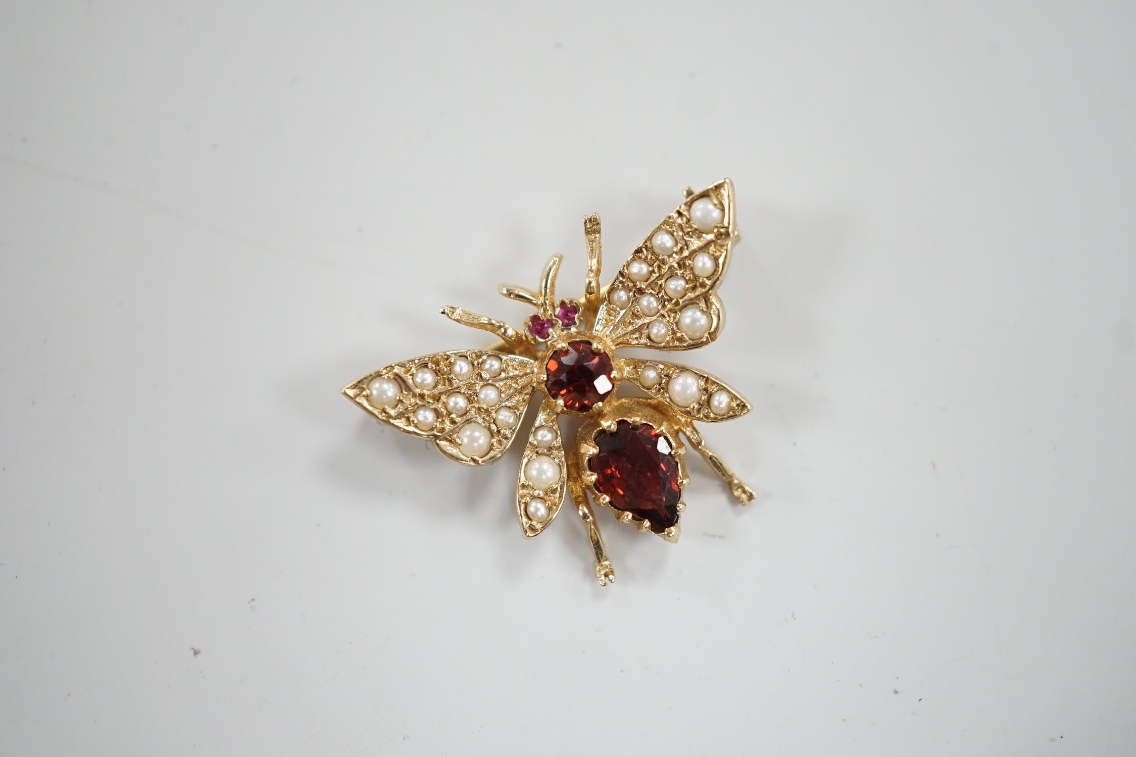 A modern 9ct gold, garnet and split pearl set bug brooch, width 26mm, gross weight 3.8 grams.